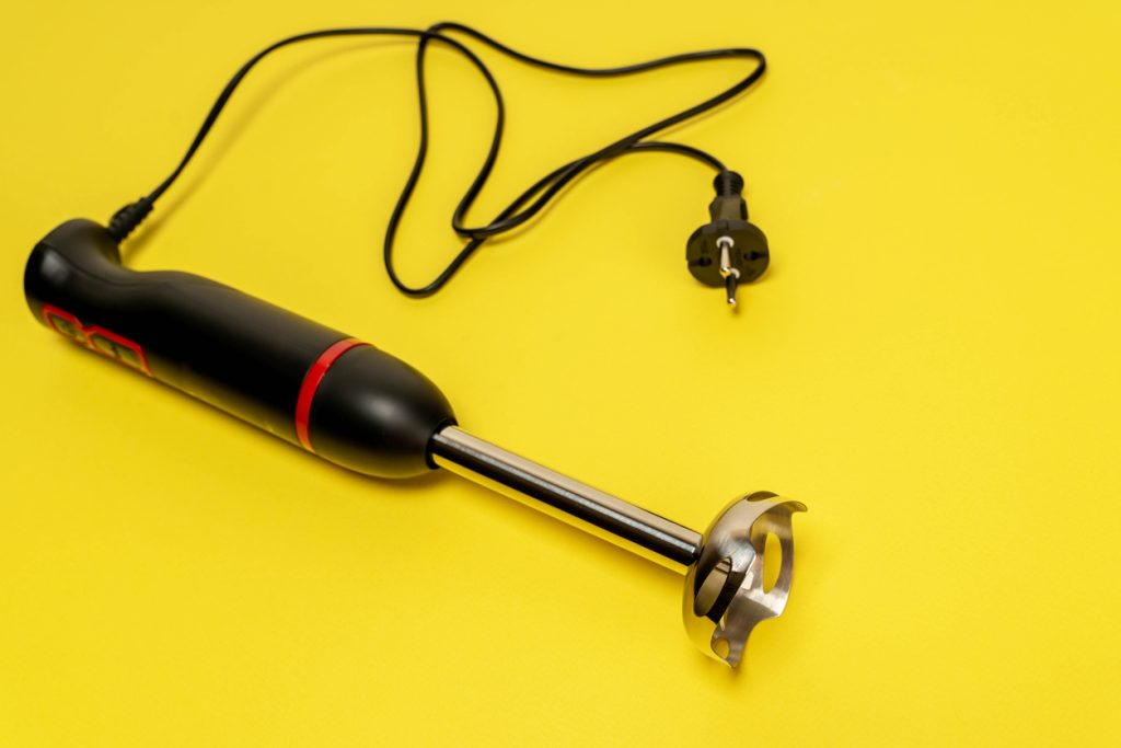 a kitchen blender on a yellow background, ready to mix and cook culinary masterpieces.