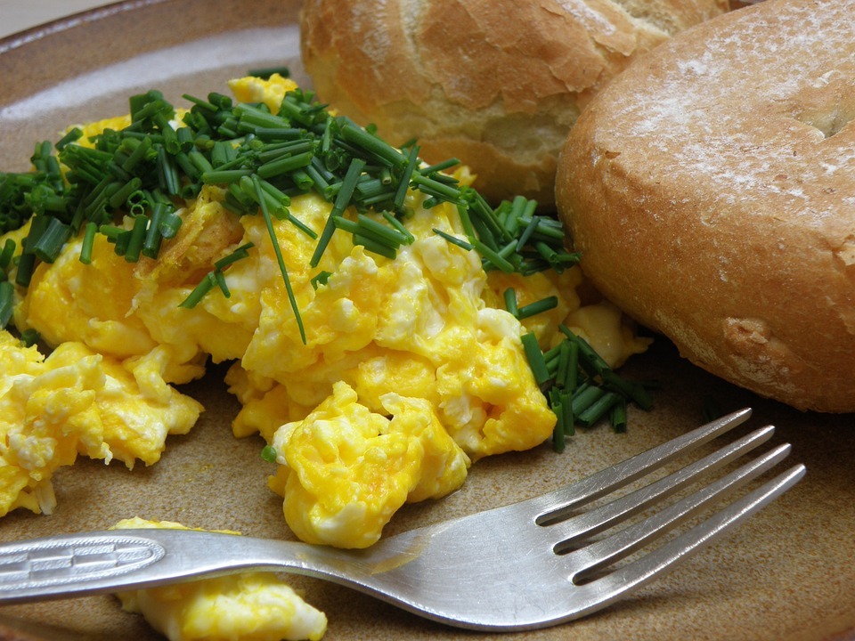 a breakfast platter with scrambled eggs and buns