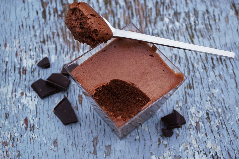 a square dessert mousse cup and a spoon with chocolate mousse on it