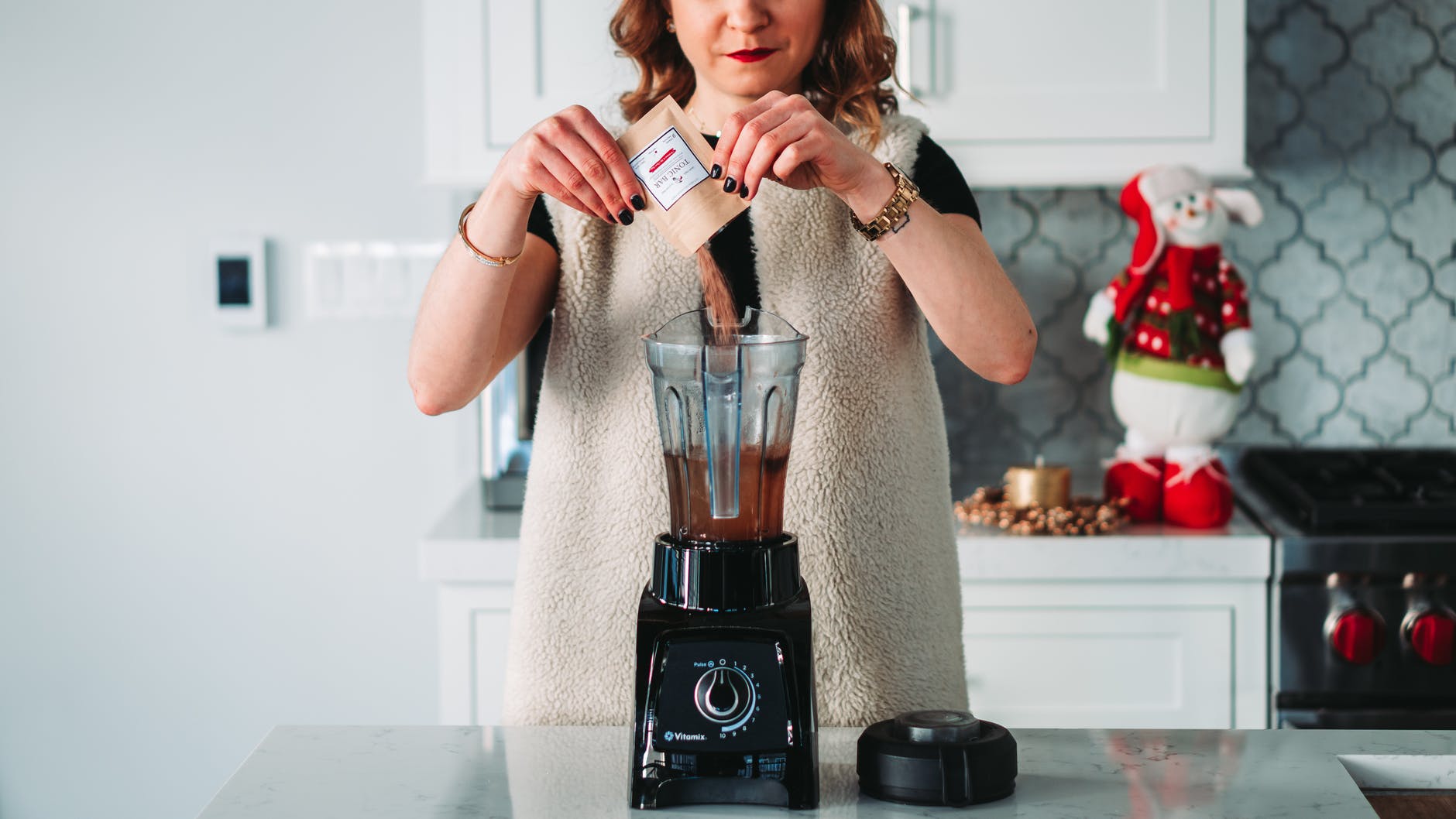 woman using a black and grey blender