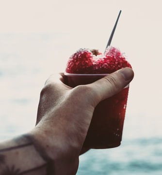 a person holding a cup of red slushie
