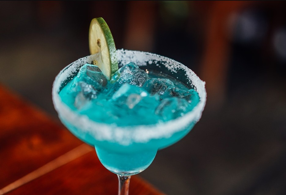 a blue margarita with a wedge of lime