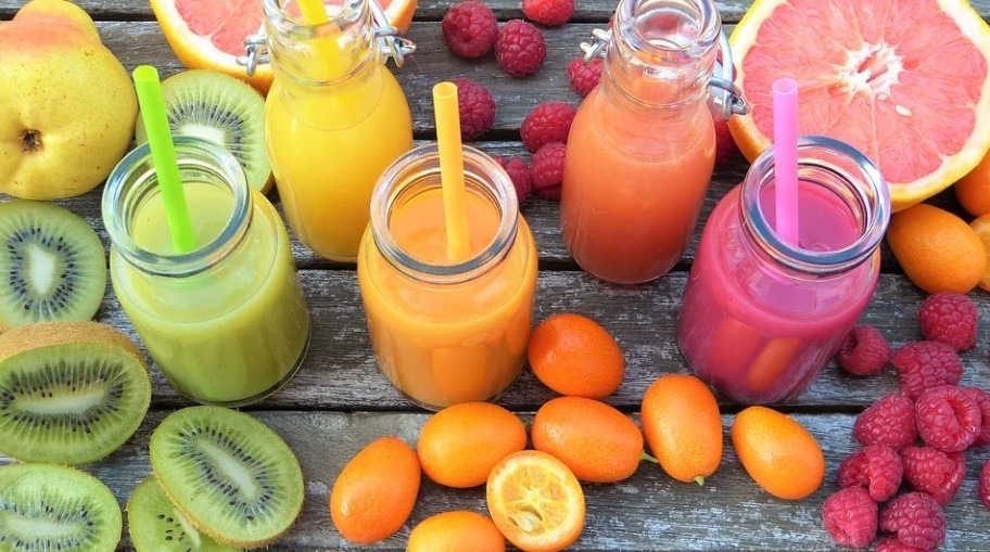 glasses of smoothies surrounded by colorful fruits